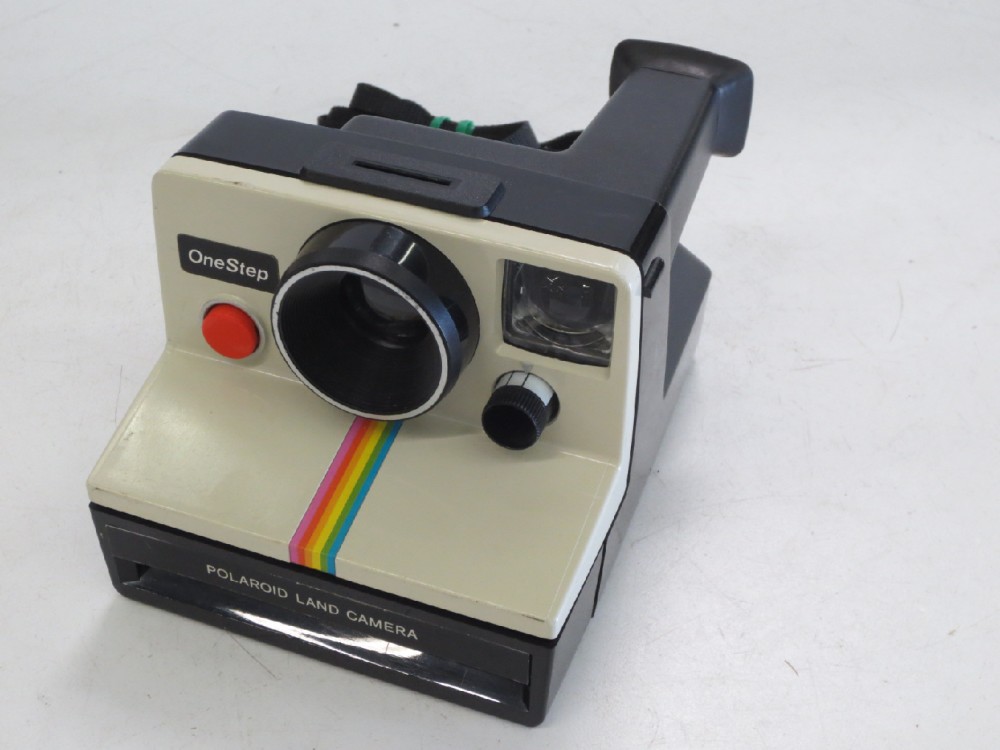 Polaroid OneStep SX 70 Model. Practical, Rubber eyecup on back, Black nylon neck strap.  Uses Polaroid SX 70 film, readily available as of 04/23/2019.  Introduced:  1972, White, Polaroid, 1970+, Plastic