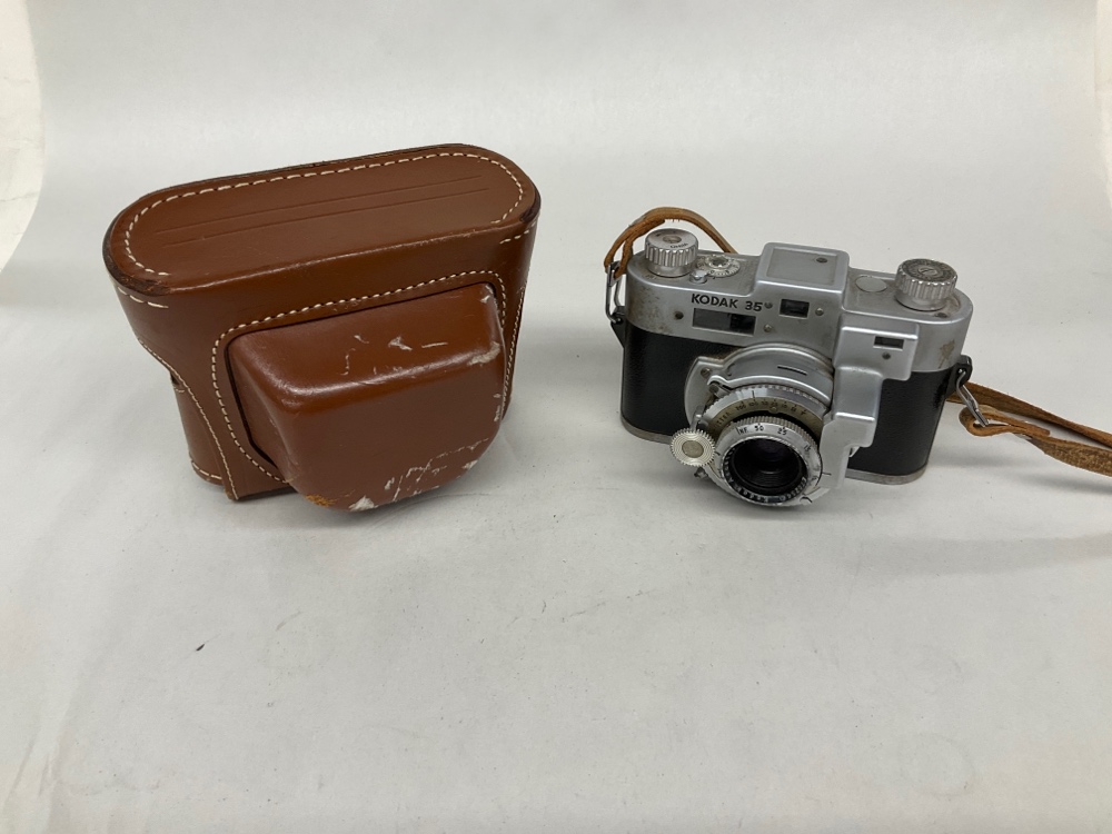 Kodak 35.  Uses 35mm film.  First 35mm camera manufactured by Kodak.  Has Case., Silver, Kodak, 1930s+, Metal