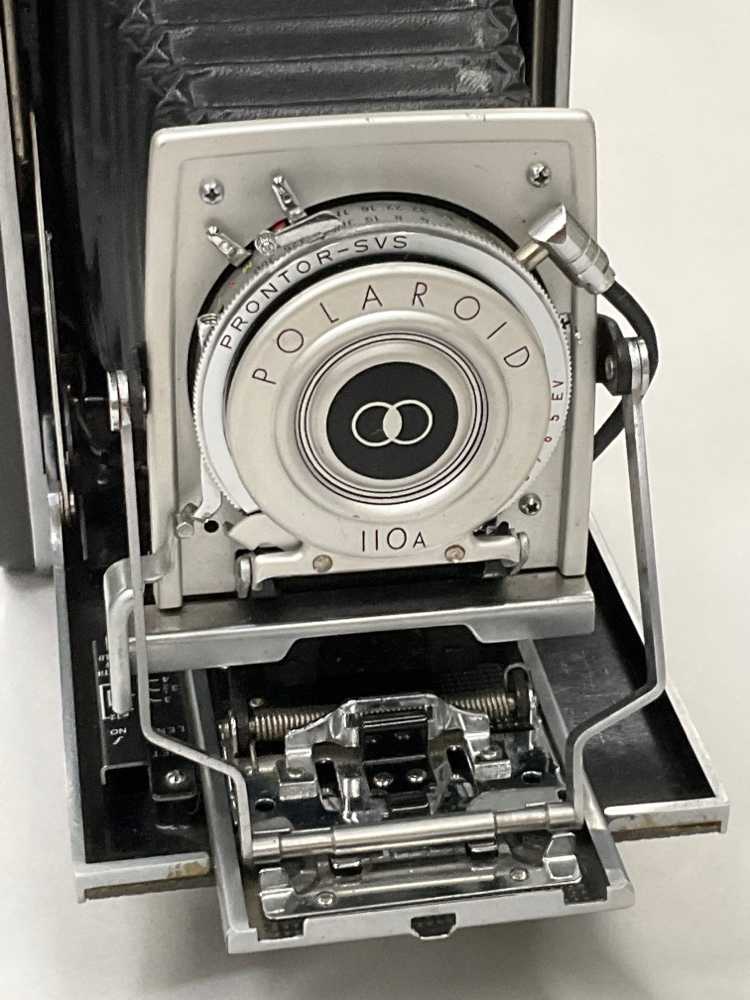 Polaroid Model 110a , Lense Expands Out, Has Small Carrying Handle.  Introduced: 1957, Black, Polaroid, 1950s+, Metal, 10"w, 5"h, 2.5"d