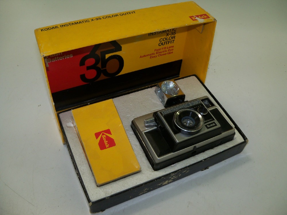 Kodak Instamatic X35 Color Outfit. Camera, Film Box And Flash Cube, Yellow, Cardboard, 8.5"W, 6"d, 3"h