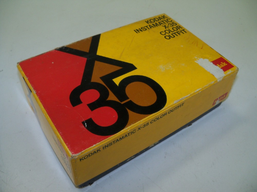 Kodak Instamatic X35 Color Outfit. Camera, Film Box And Flash Cube, Yellow, Cardboard, 8.5"W, 6"d, 3"h